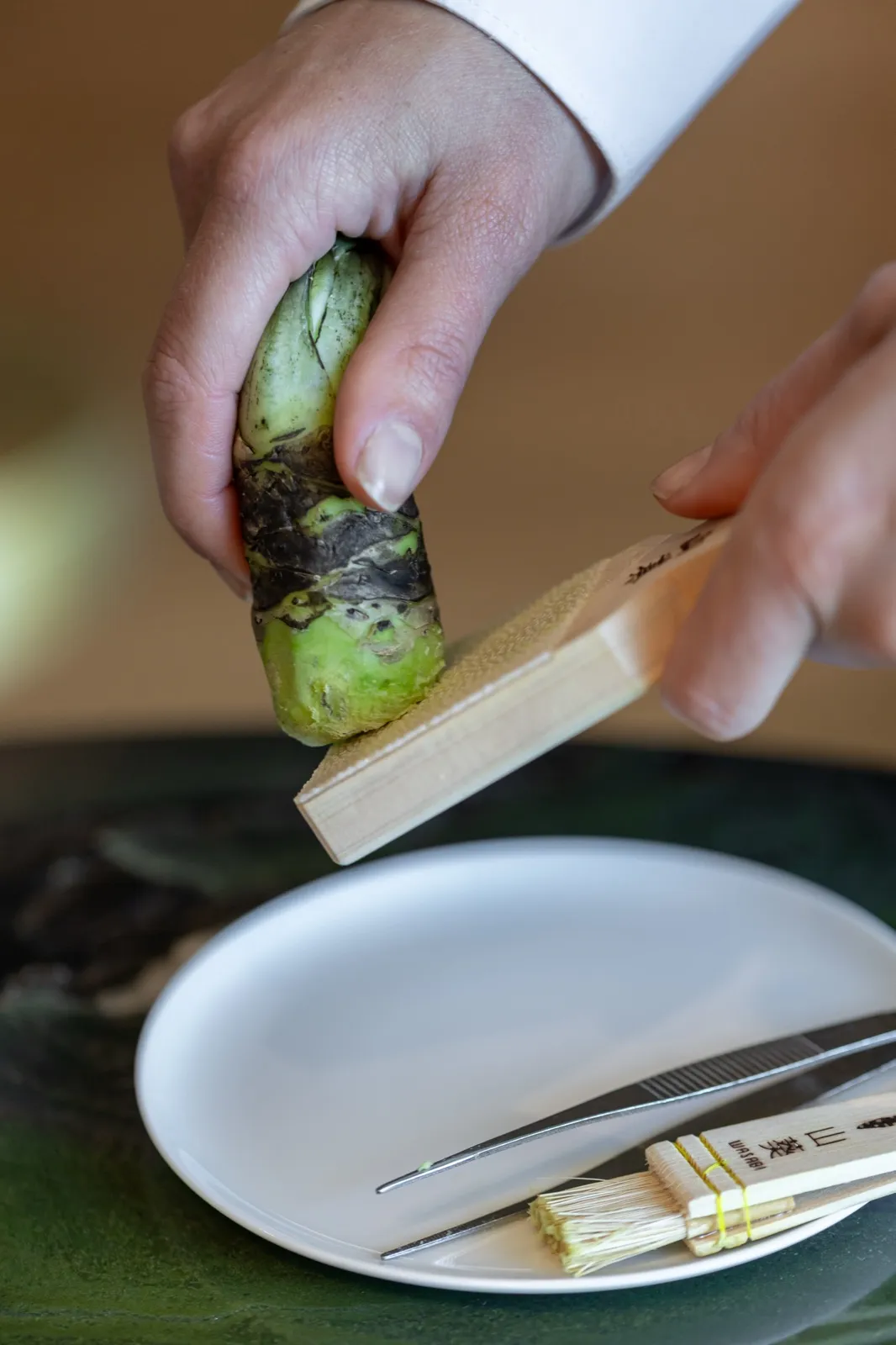 Un geste en cuisine, au-dessus d’une assiette