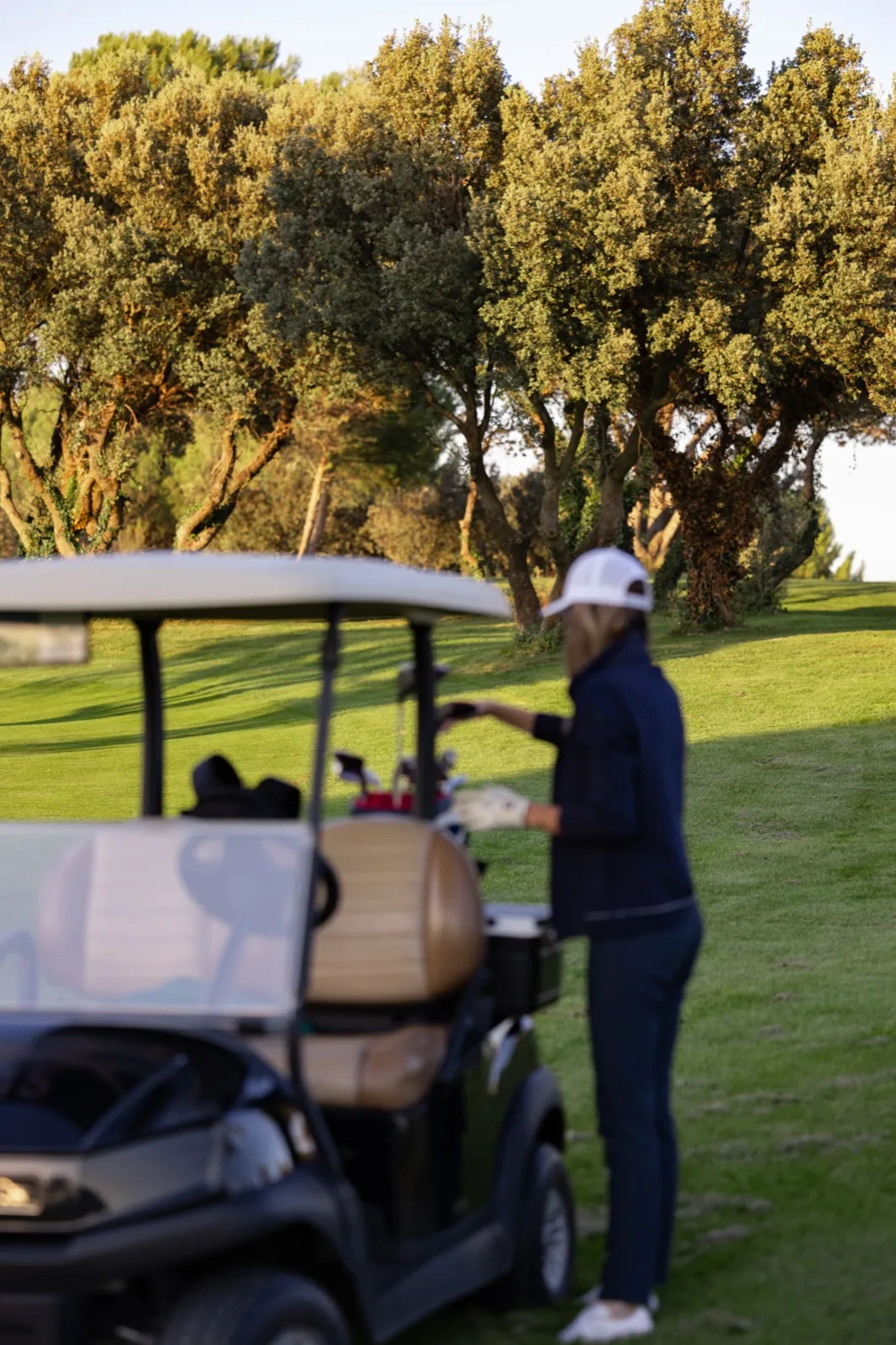 Une golfeuse près de sa voiturette