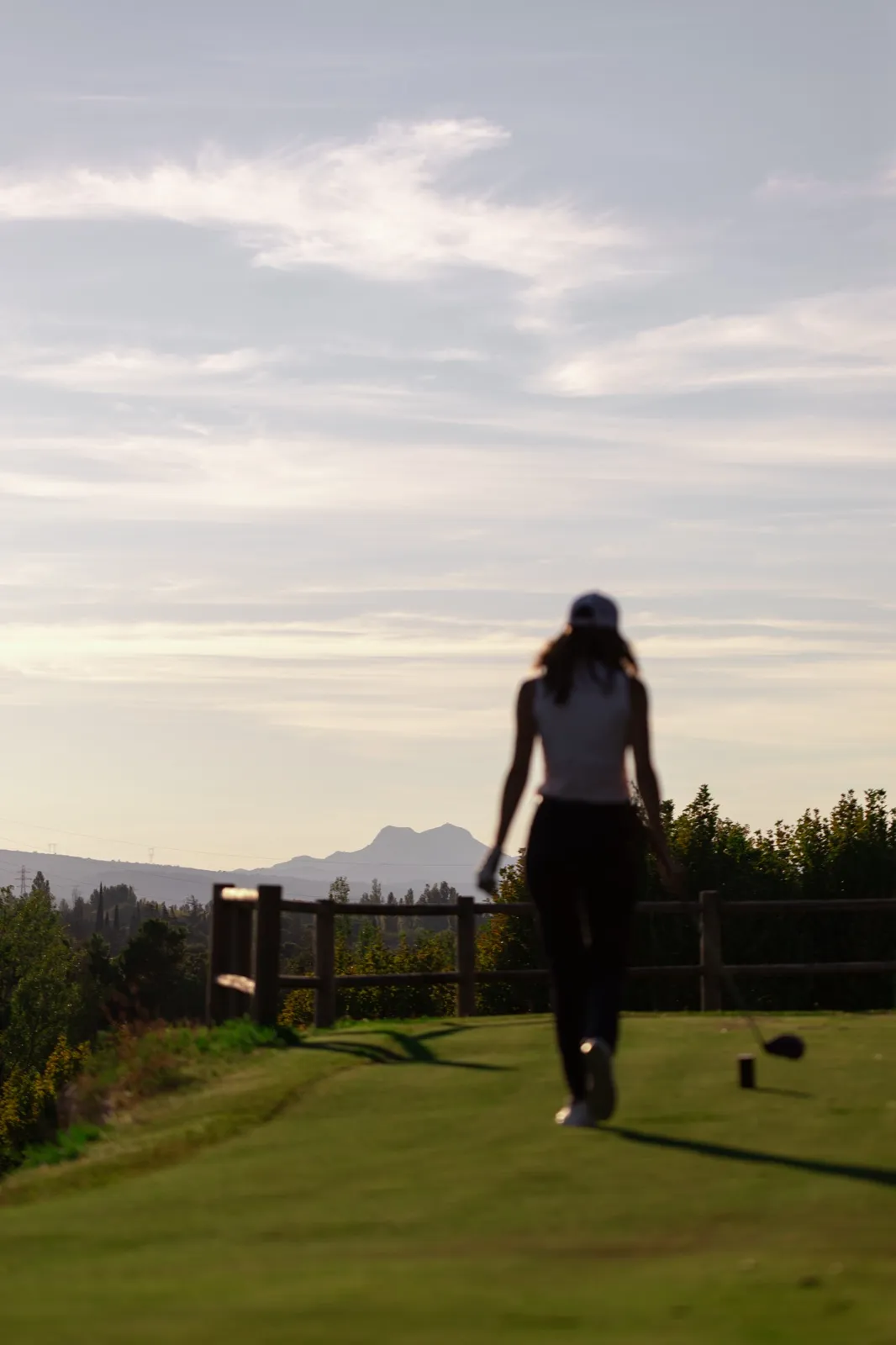 Une golfeuse en silhouette, en fin de journée