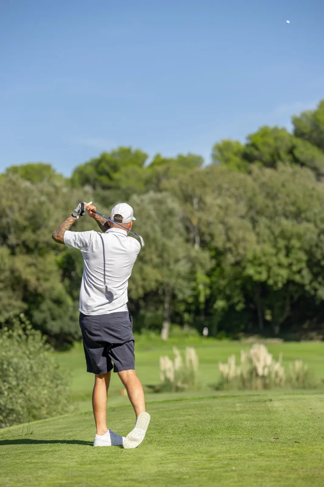 Un golfeur qui termine son swing