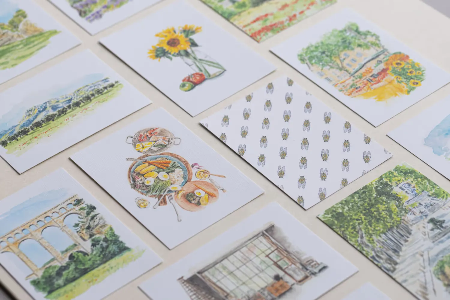 Cartes postales aquarelle d’umawi étalées sur une table